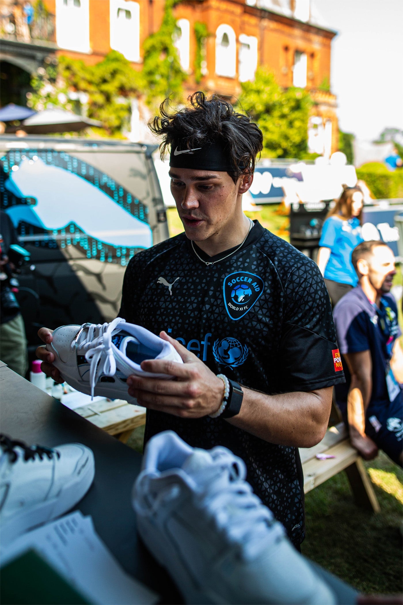 TikTok Star Noah Beck holding his at custom sneaker at Socceraid
